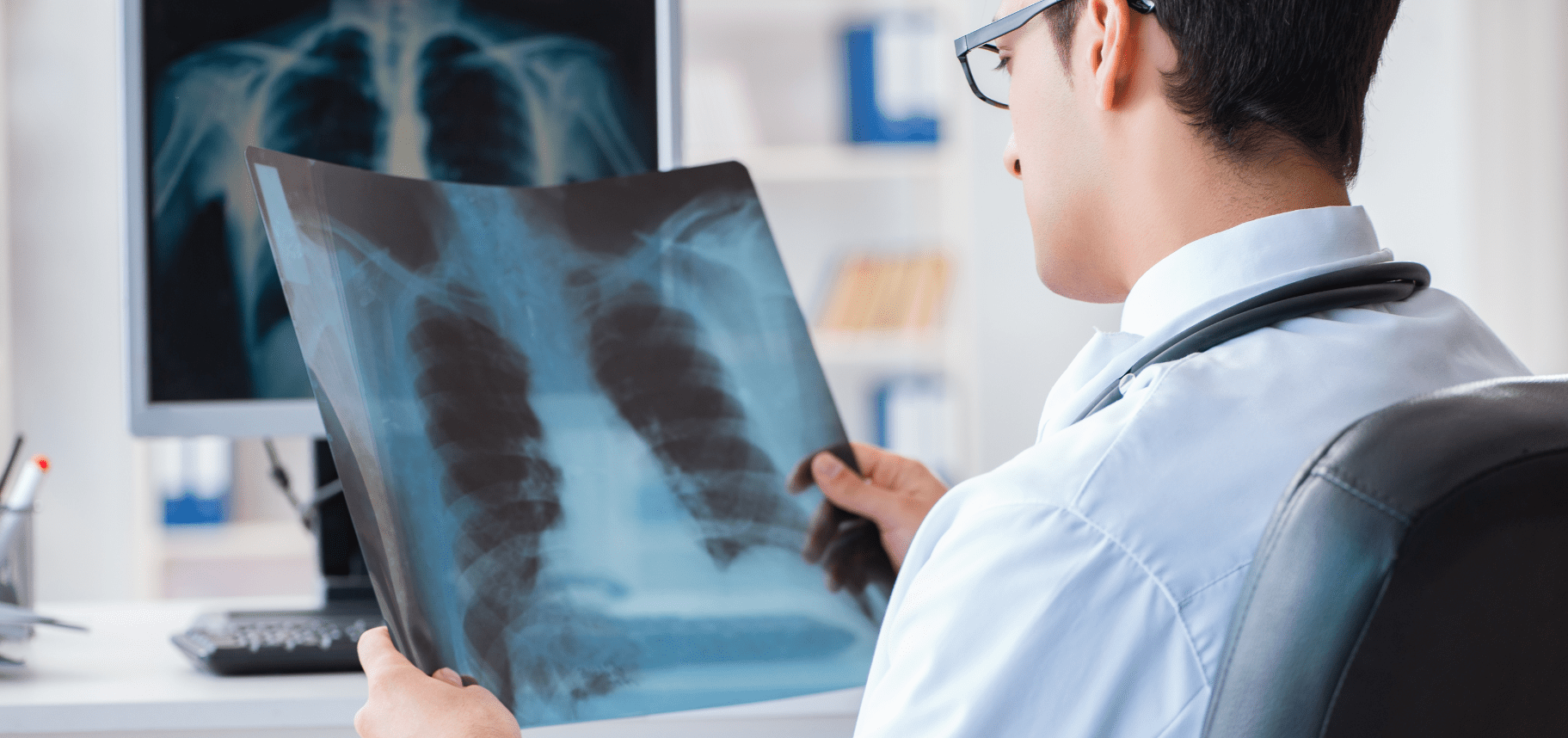 Male doctor reviewing x-rays for research purposes