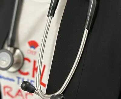 A woman wearing a stethoscope to help diagnose pulmonary fibrosis sooner